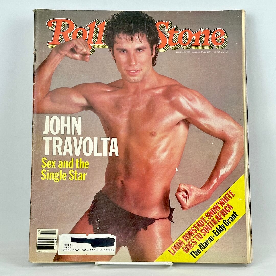 Vintage issue of Rolling Stone magazine featuring John Travolta in loincloth striking bodybuilding pose. 