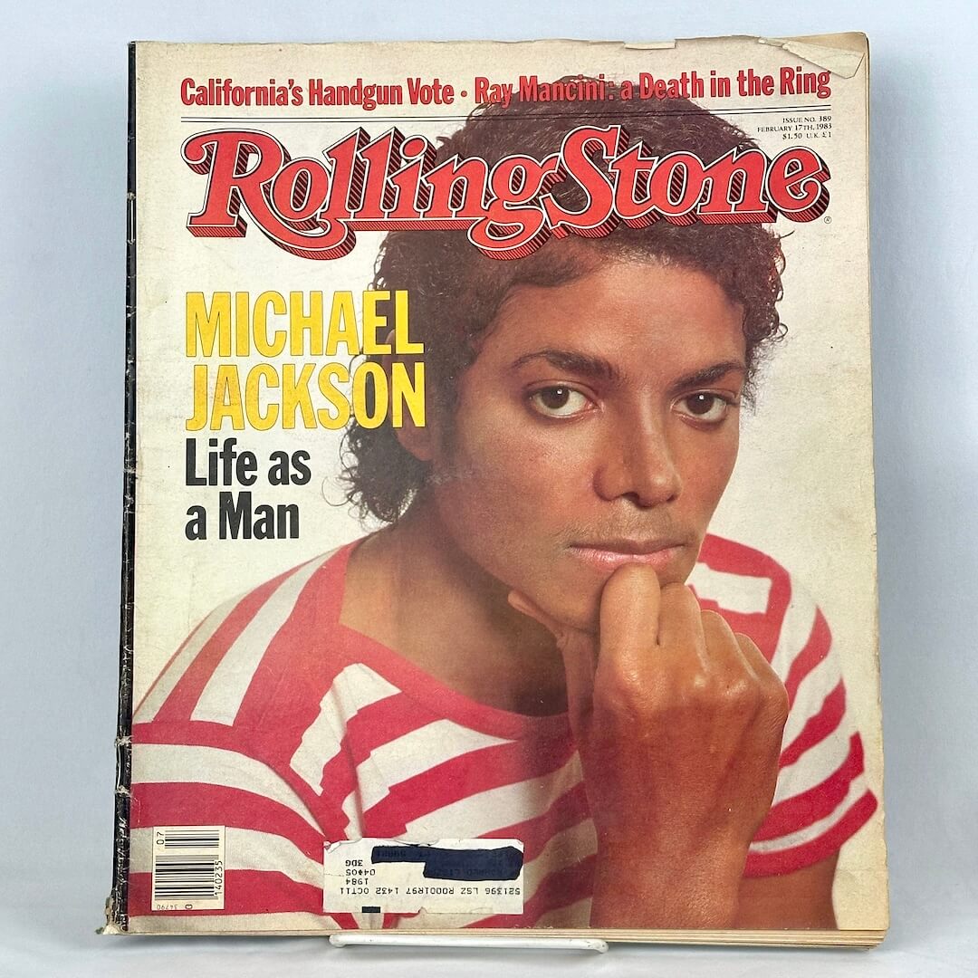 A vintage Rolling Stone magazine cover featuring Michael Jackson in red and white striped shirt. 