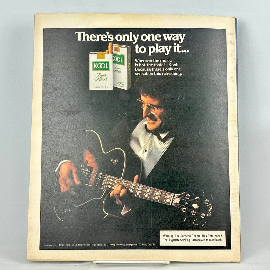 Back cover of magazine with full page ad for Kool cigarettes featuring a photo of a man playing guitar. 