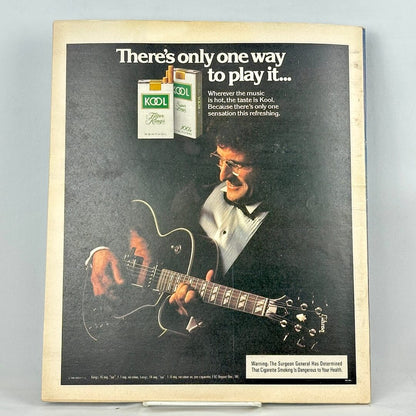 Back cover of magazine with full page ad for Kool cigarettes featuring a photo of a man playing guitar. 