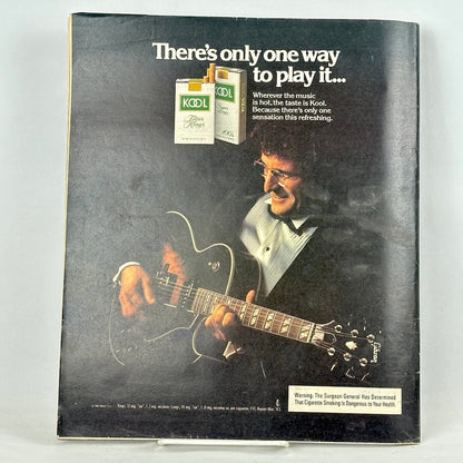 Back cover of magazine with full page ad for KOOL cigarettes featuring man in tuxedo playing guitar.