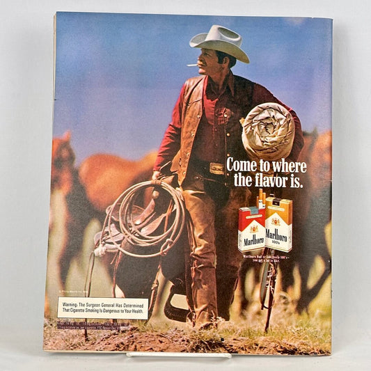 Back cover of magazine with full page ad for Marlboro cigarettes featuring a cowboy carrying a saddle. 
