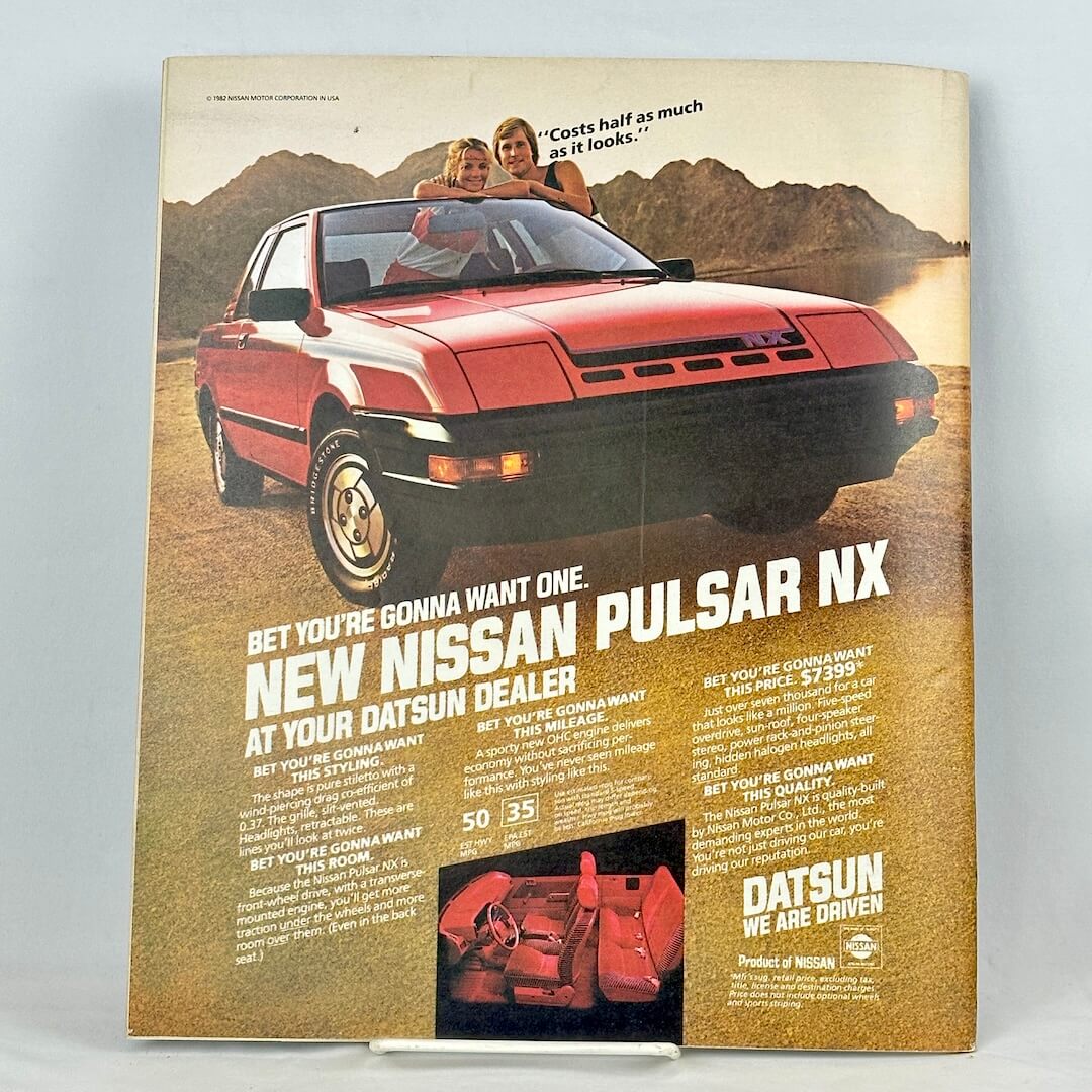 Back cover of magazine with full page ad for a Datsun vehicle set on a beach. 