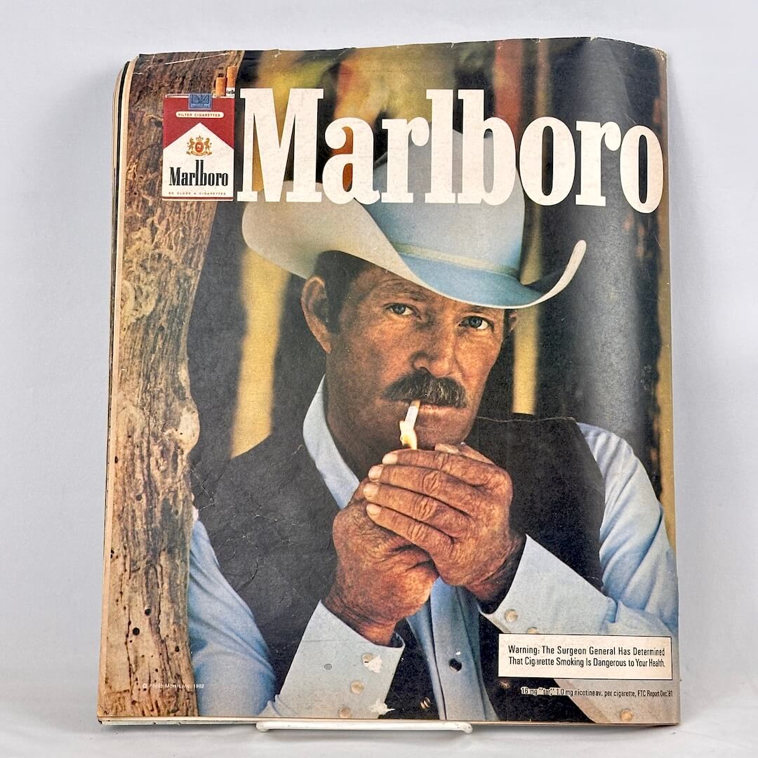 Back cover of magazine with full page ad for Marlboro cigarettes and a photo of a cowboy lighting a cigarette. 