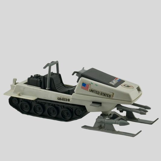 White & grey snowmobile with black tracks, grey missiles on either leg, double gun at nose, & G.I. Joe sticker decals. 
