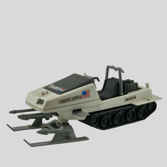 White & grey snowmobile with black tracks, grey missiles on either leg, double gun at nose, & G.I. Joe sticker decals. 