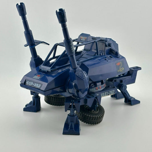 Blue tactical vehicle with four legs, two wheels, roll cage, twin cannons at front, & tow hitch, with red & white Cobra decals.