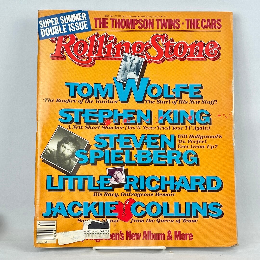 A vintage 1984 issue of Rolling Stone magazine, featuring a bright orange cover with large red and blue text. 