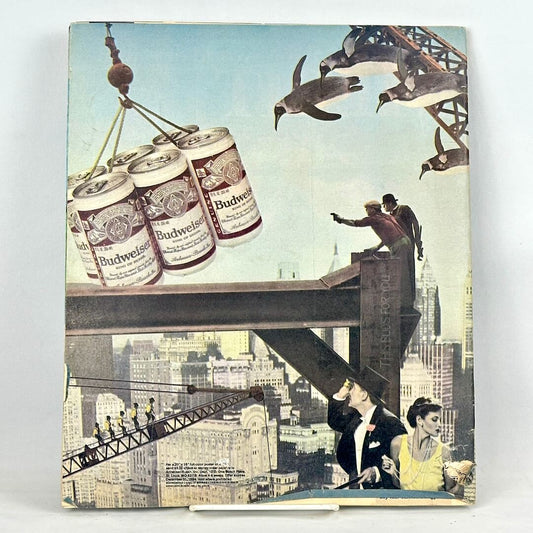 Back cover of magazine with full page ad for Budweiser with surreal urban landscape as background. 