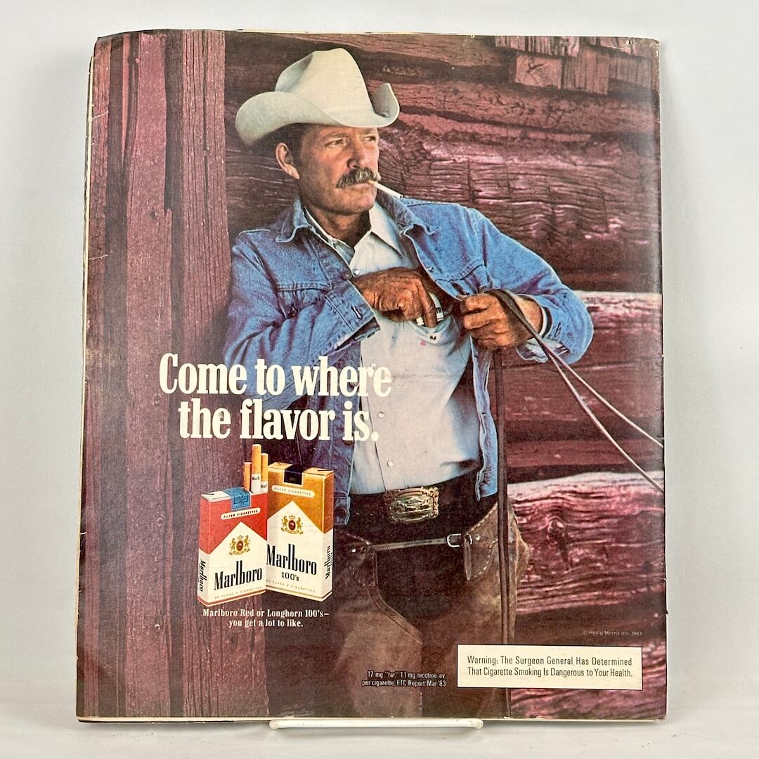 Back cover of magazine with full page ad for Marlboro cigarettes featuring image of smoking cowboy. 