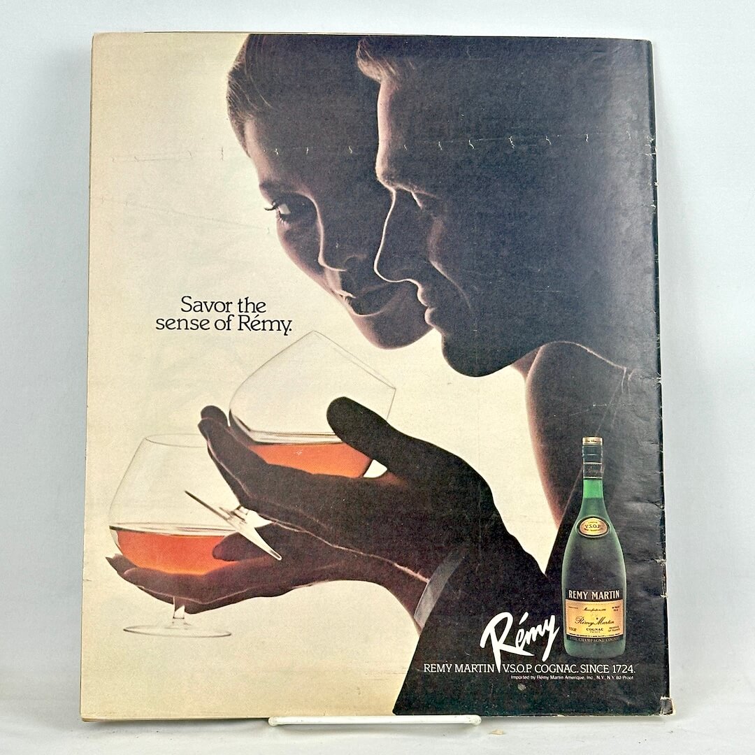 Back cover of magazine with full page ad for Remy Martin cognac with two silhouettes holding glasses. 