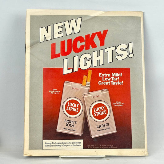 A vintage Lucky Strike Lights cigarette advertisement on back cover of magazine featuring cigarette packs. 