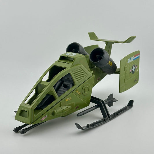 Army green helicopter with twin grey engines, two grey missiles on landing gear, gun at front, & G.I. Joe sticker decals.