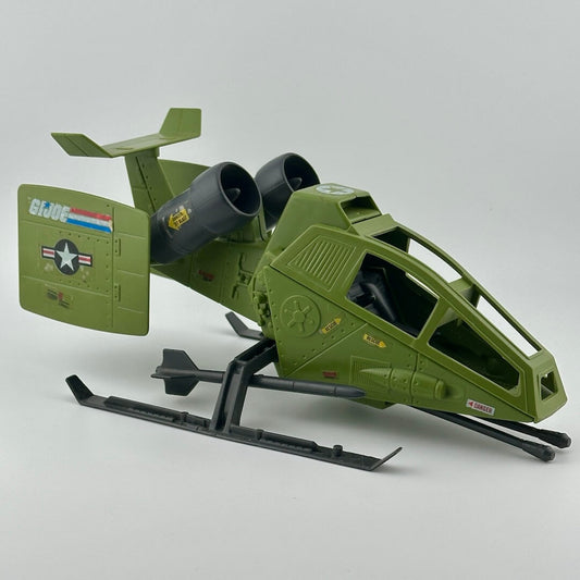 Army green helicopter with twin grey engines, two grey missiles on landing gear, gun at front, & G.I. Joe sticker decals