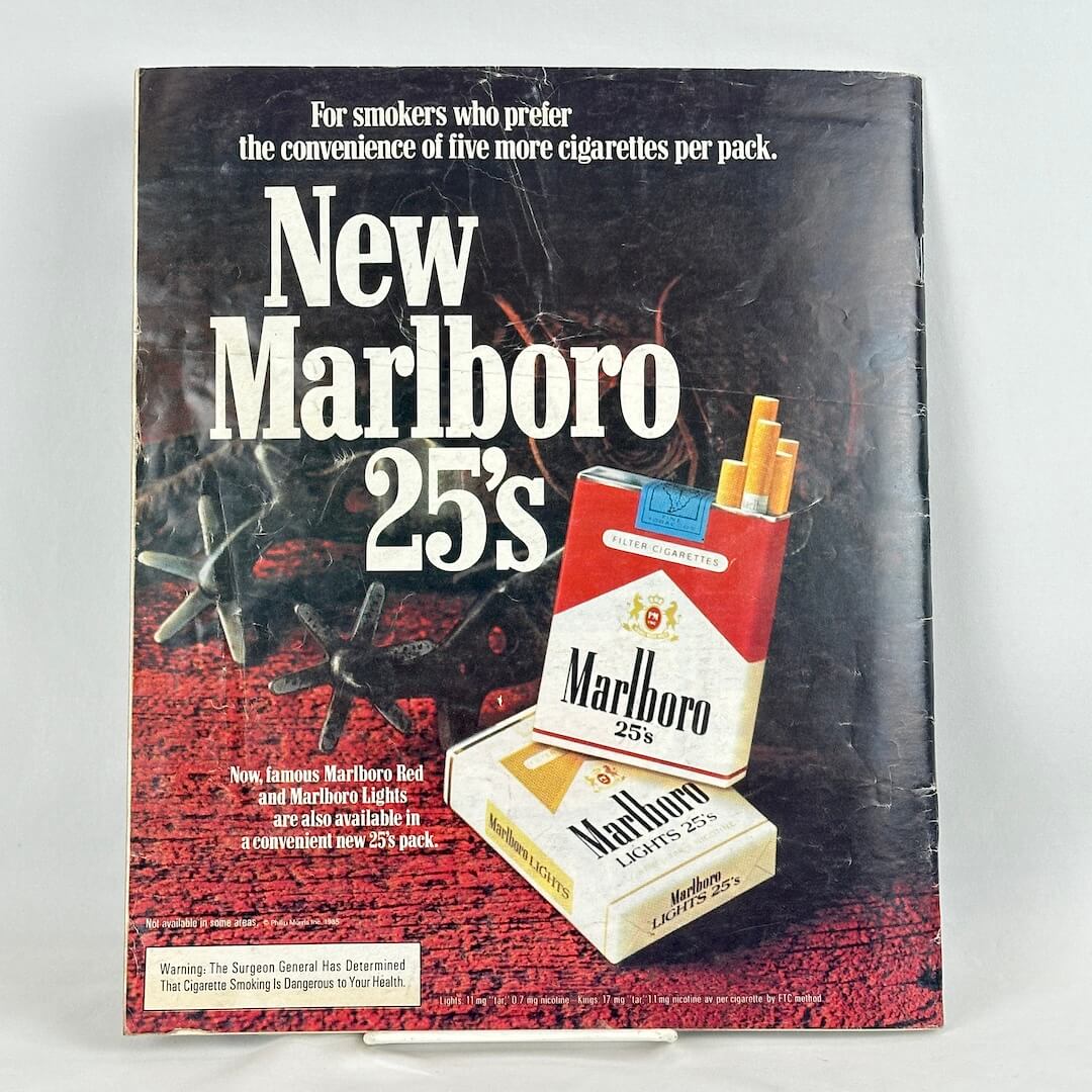 Back cover of magazine with full page ad for Marlboro cigarettes featuring two packs of cigarettes next to spurs. 