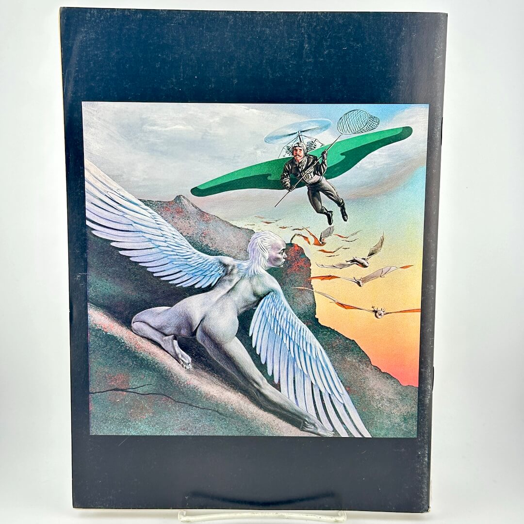 Back cover of magazine with winged woman hiding from man with glider wings and net. 