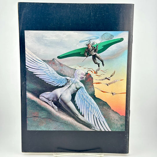 Back cover of magazine with winged woman hiding from man with glider wings and net. 