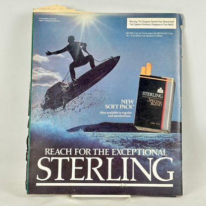 Back cover of magazine with full page ad for Sterling cigarettes featuring image of surfing guy and pack of smokes. 