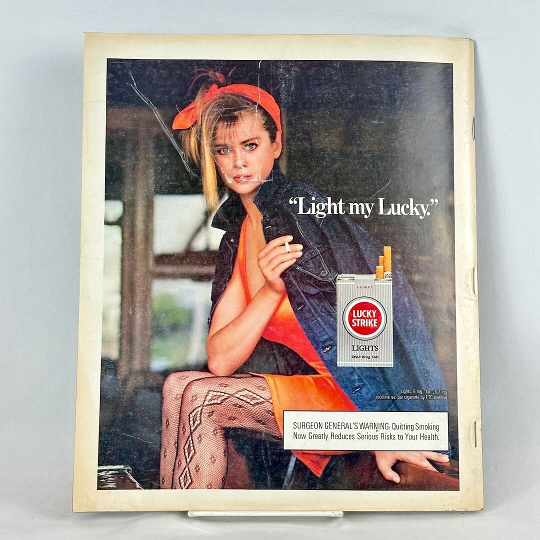 Back cover of magazine with full page ad for Lucky Strike cigarettes featuring a woman in jean jacket holding a cigarette.