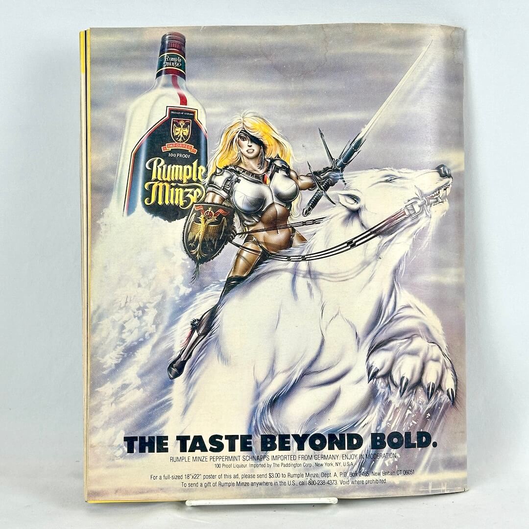 Back cover of magazine with full page ad for Rumple Minze liquor with warrior woman on the back of polar bear. 