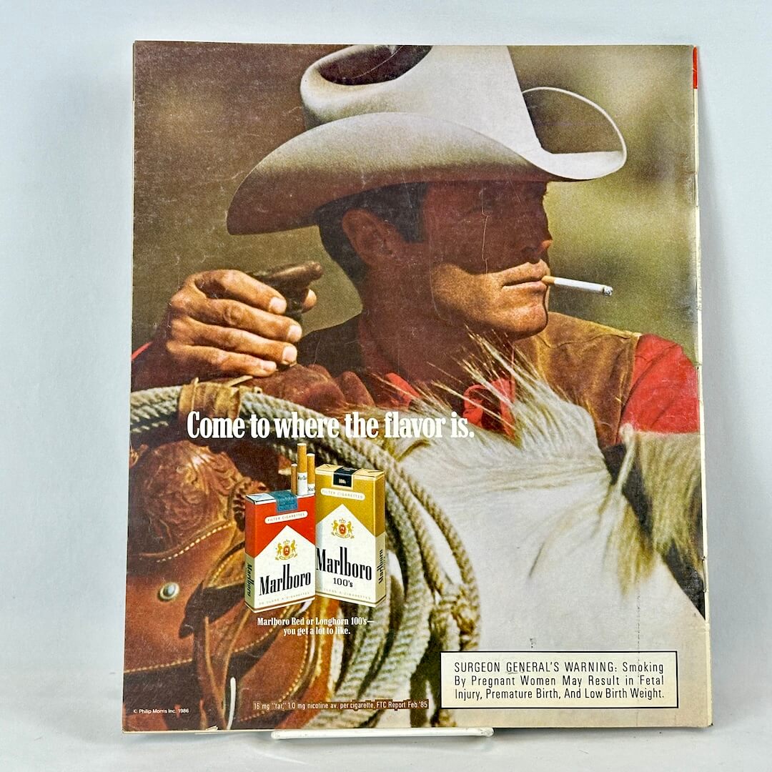 Back cover of magazine with full page ad for Marlboro cigarettes featuring image of smoking cowboy. 