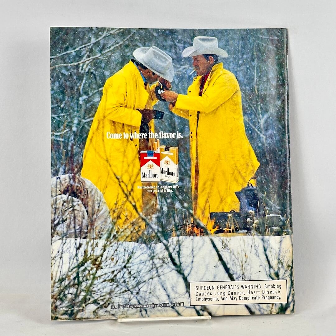 Back cover of magazine with full page ad for Marlboro cigarettes featuring two smoking cowboys in winter scene.