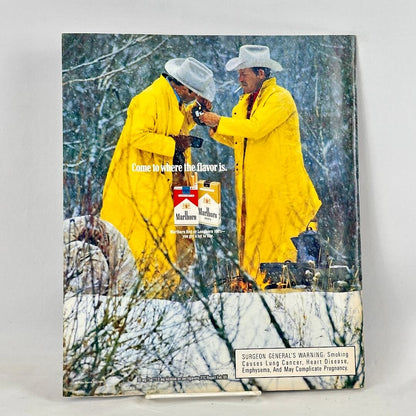 Back cover of magazine with full page ad for Marlboro cigarettes featuring two smoking cowboys in winter scene.