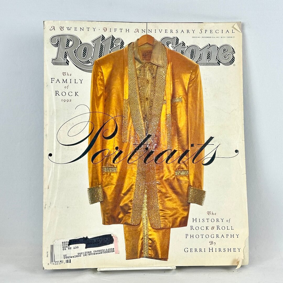Vintage issue of Rolling Stone magazine with cover photo of Elvis' gold suit on white background. 