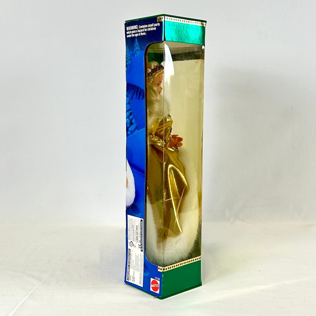 Side view of Barbie in gold dress still in box