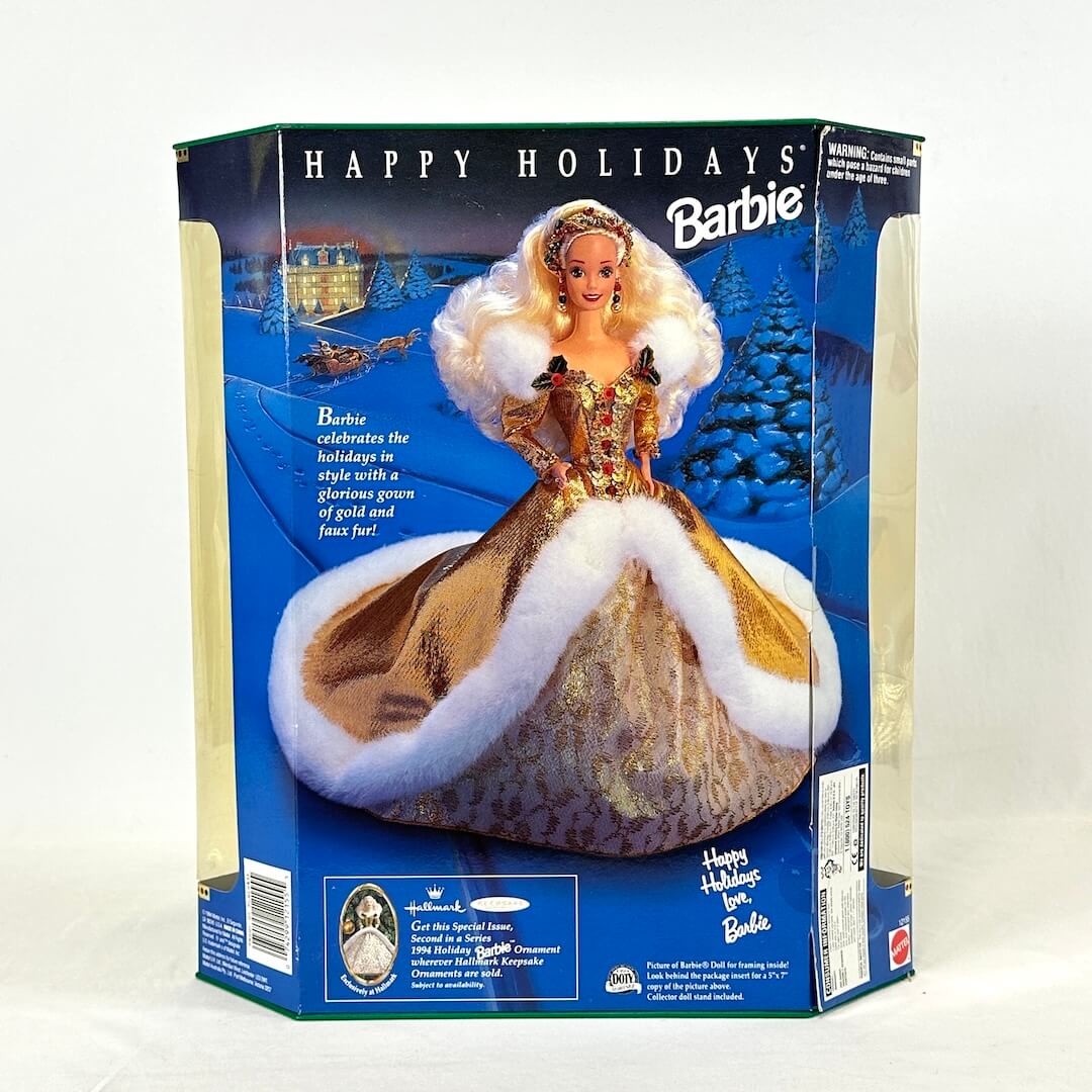 Barbie doll in a gold and white dress with 'Happy Holidays' packaging