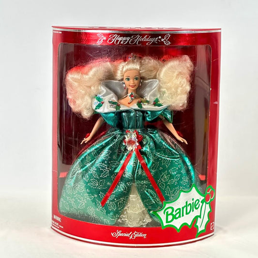 Barbie doll in a green dress with red accents in a Happy Holidays packaging.