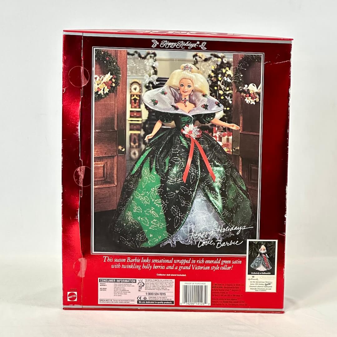 Barbie doll in a green dress with a red ribbon in a decorative box