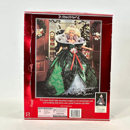 Barbie doll in a green dress with a red ribbon in a decorative box