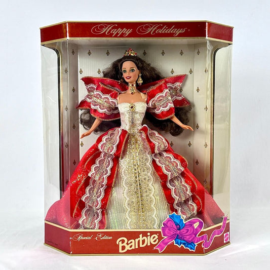 Barbie doll in a festive dress with red and white accents, surrounded by decorative ribbons, in a 'Happy Holidays' themed box.