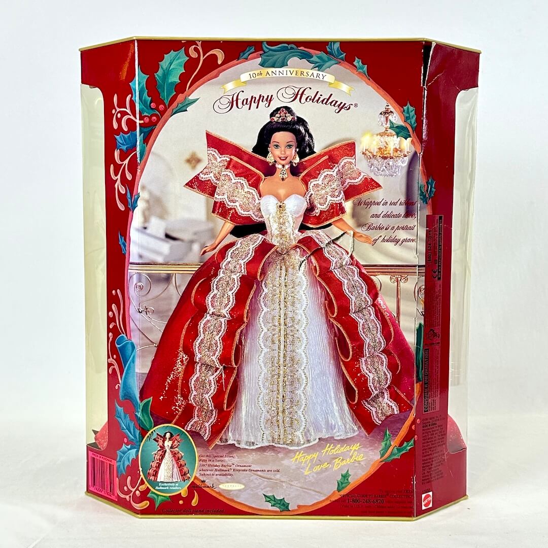 Barbie doll in a festive red and white dress with decorative box on a white background