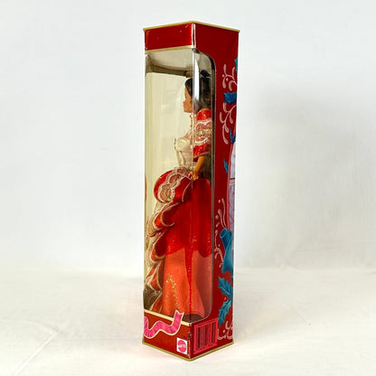 Doll in a decorative box with red and gold design on a white background