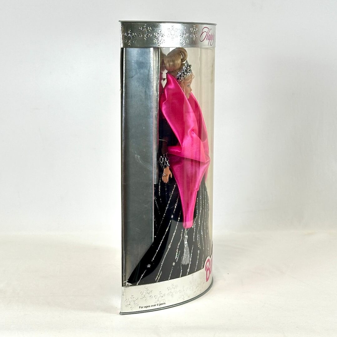Barbie doll in a black dress inside packaging on a white background