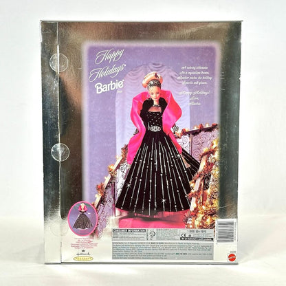 Barbie doll in a festive outfit with pink cape and black dress, surrounded by Christmas decorations on packaging.