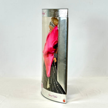 Barbie doll in a black dress with a silver tiara in packaging on a white background