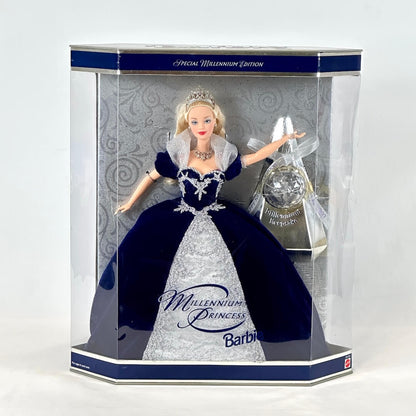 Barbie doll in a navy blue and white gown with a tiara, displayed in a clear box.