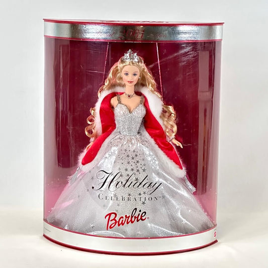 Barbie doll in a festive outfit inside a cylindrical box with 'Holiday Celebration Barbie' branding.