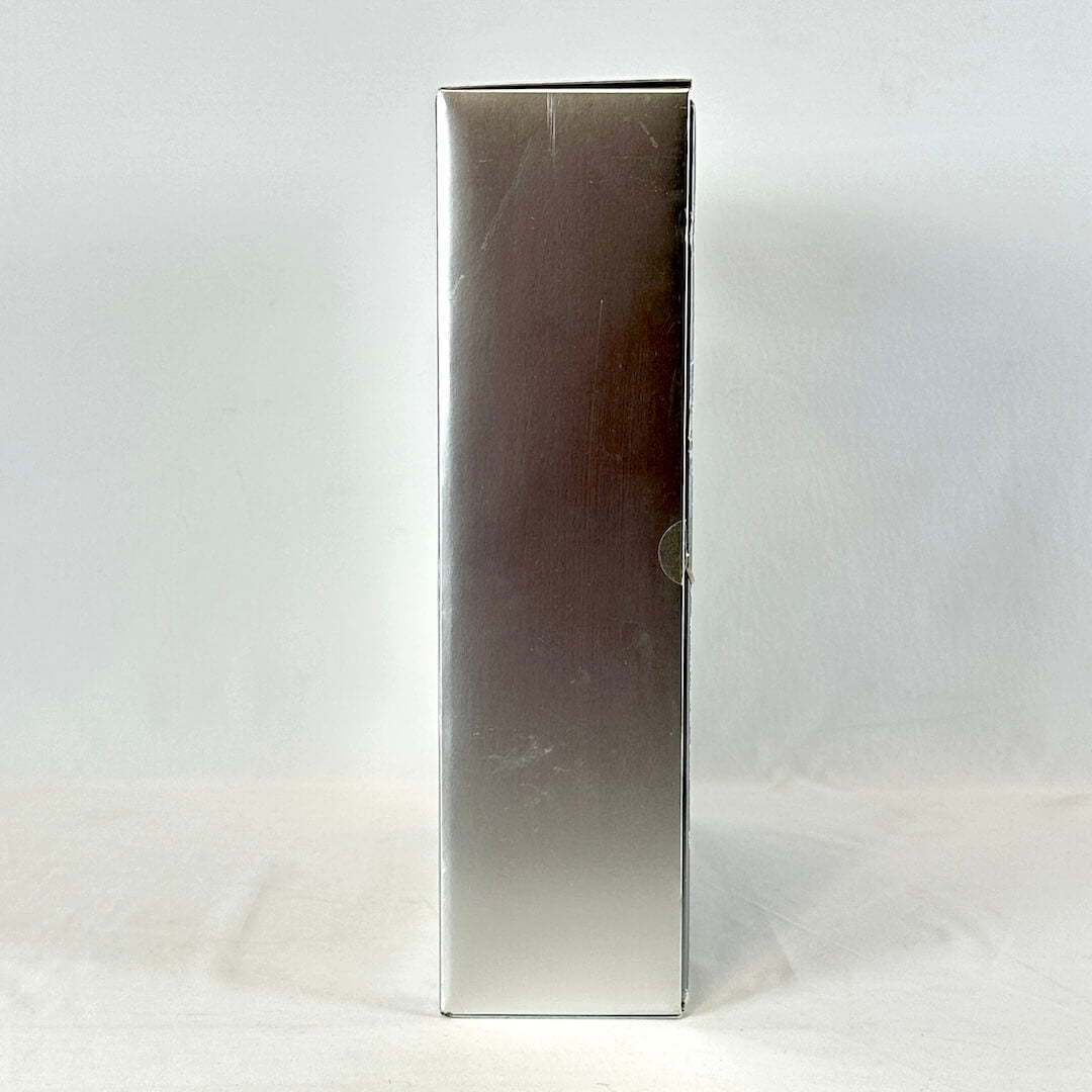 Silver rectangular object on a white background, side view of Barbie packaging.