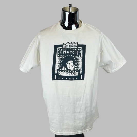White short sleeve t-shirt with black/white graphic on chest of “24 Hour Church of Elvis” with image of The King in center.