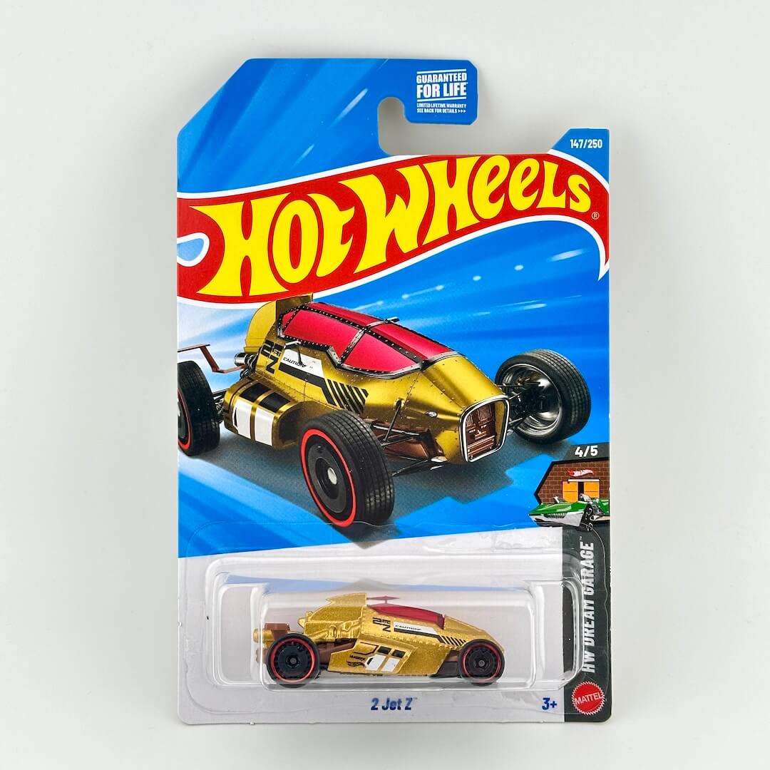 A Hot Wheels '2 Jet Z' die-cast toy car in its original blister card packaging, featuring a gold and red car.