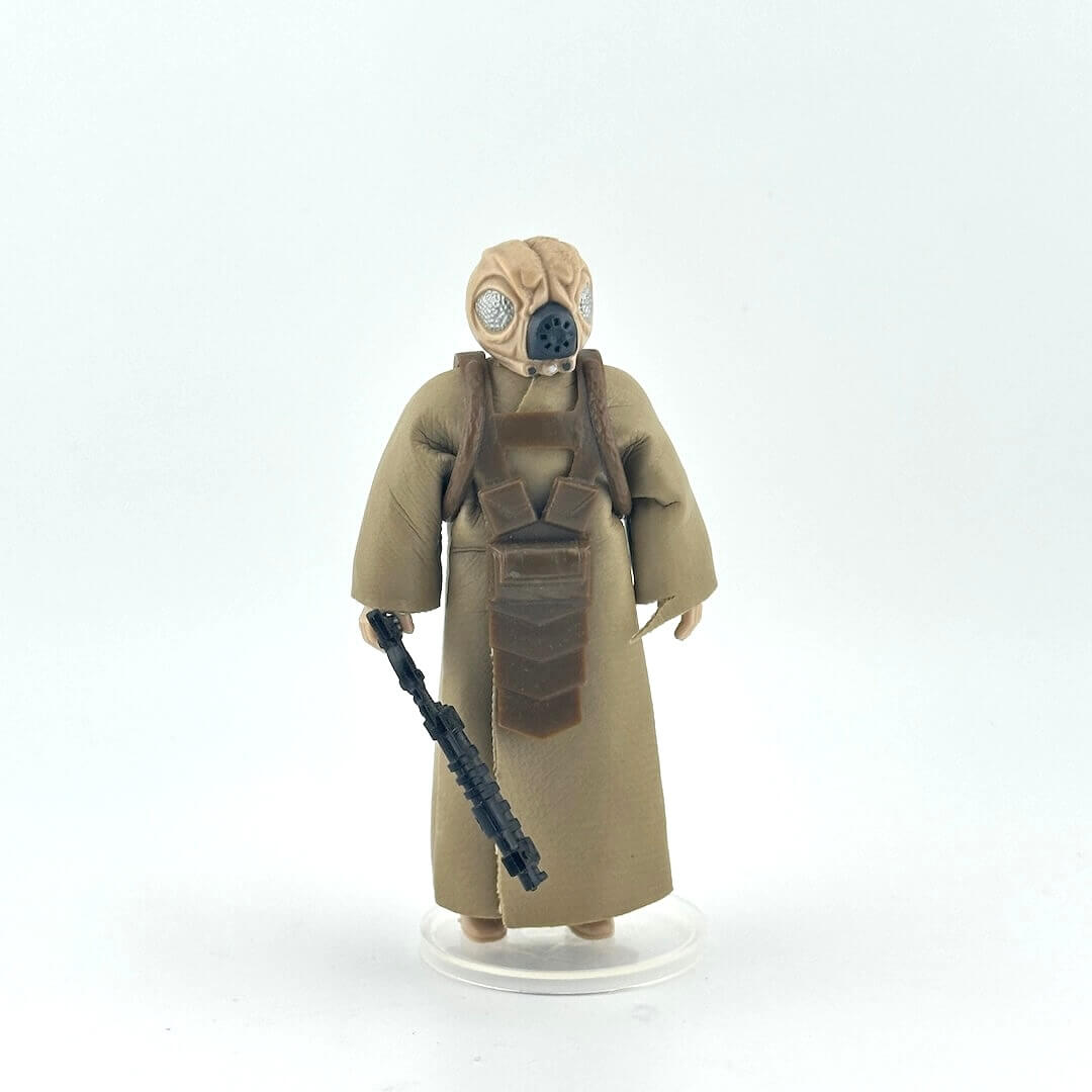 Action figure in a beige costume with a black gun on a white background