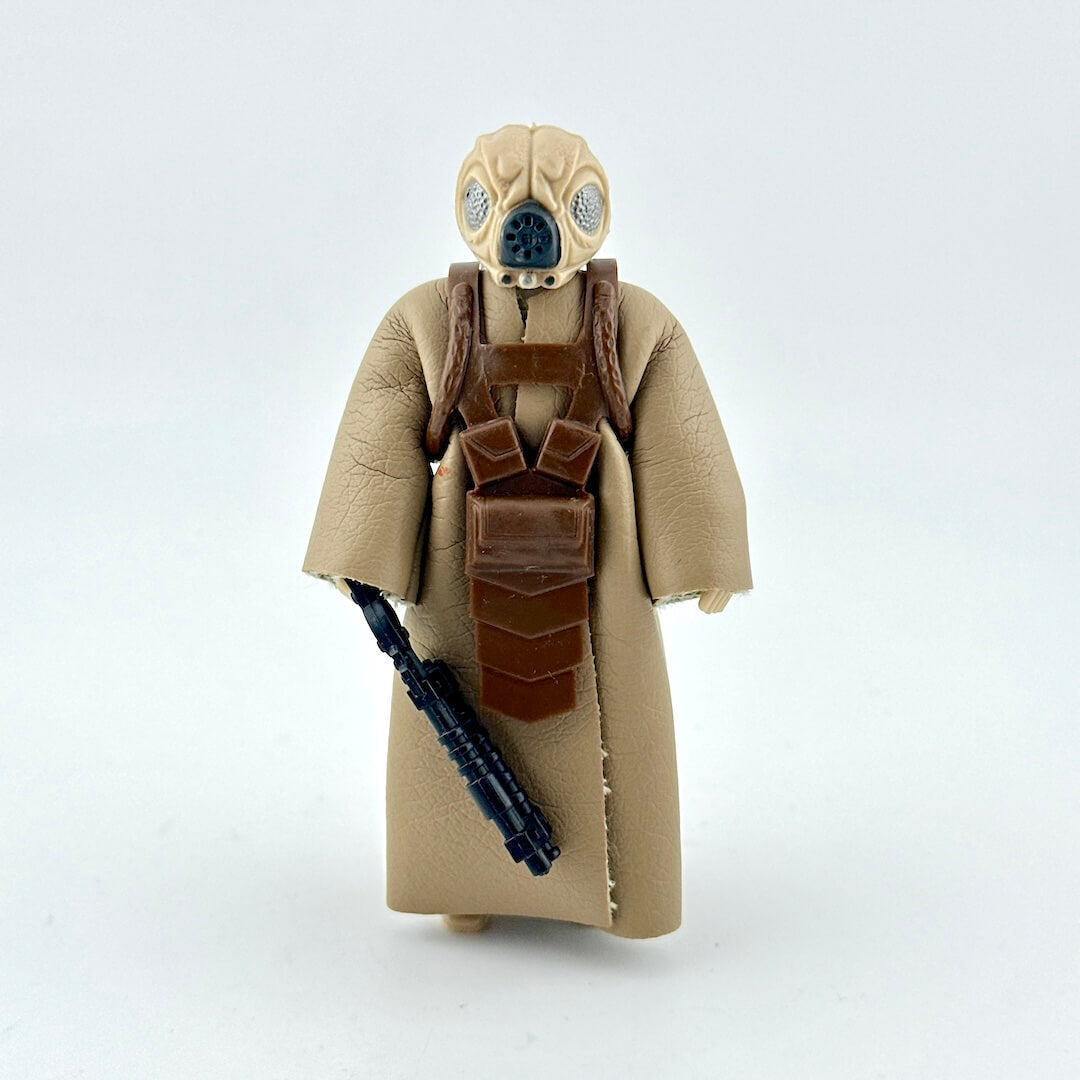 Action figure in a beige costume with a helmet and weapon on a white background