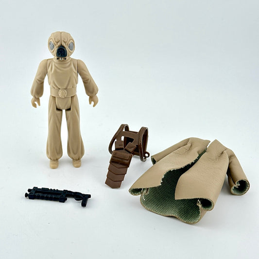 Toy figure of a character in a beige suit with accessories on a white background