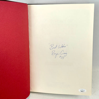 Open book with red cover and beige interior page with handwritten text on a gray background