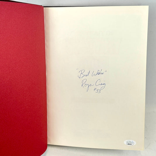 Open book with red cover and beige interior page with handwritten text on a gray background