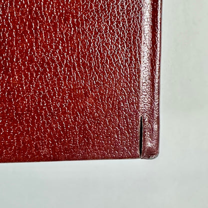 Close-up of a red leather book corner on a light gray background